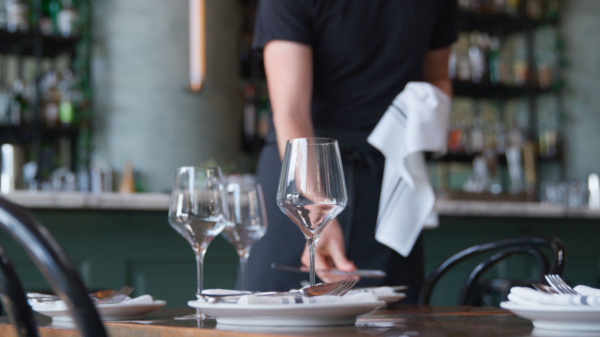 Close Up Of Male Server Laying Place Setting On Restaurant Table